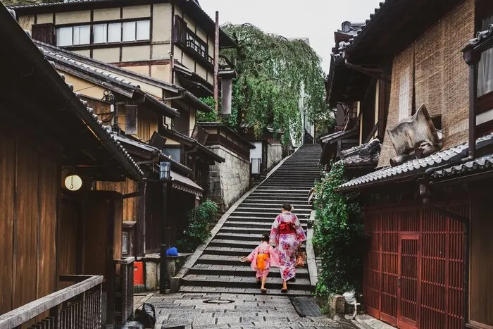 A professional guide leading a tour group through a beautiful Japanese garden.